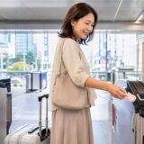 韓国の地下鉄改札でTmoneyキーホルダーをタッチする日本人旅行者